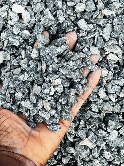 Crushed granite chippings held in hand at a quarry